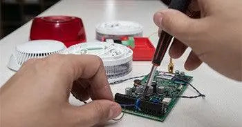 Installation de carte électronique de sécurité avec alarmes et détecteurs sur une table