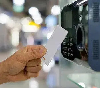 Main tenant badge RFID devant un lecteur de contrôle d'accès sécurisé, sécurité entreprise.