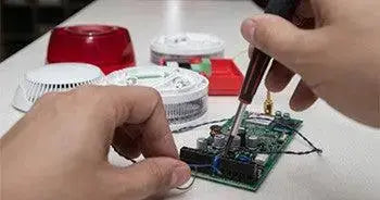 Installation de carte électronique de sécurité avec alarmes et détecteurs sur une table