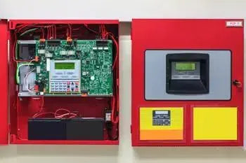 Coffret d'alarme incendie rouge ouvert, carte électronique et module de contrôle affichés